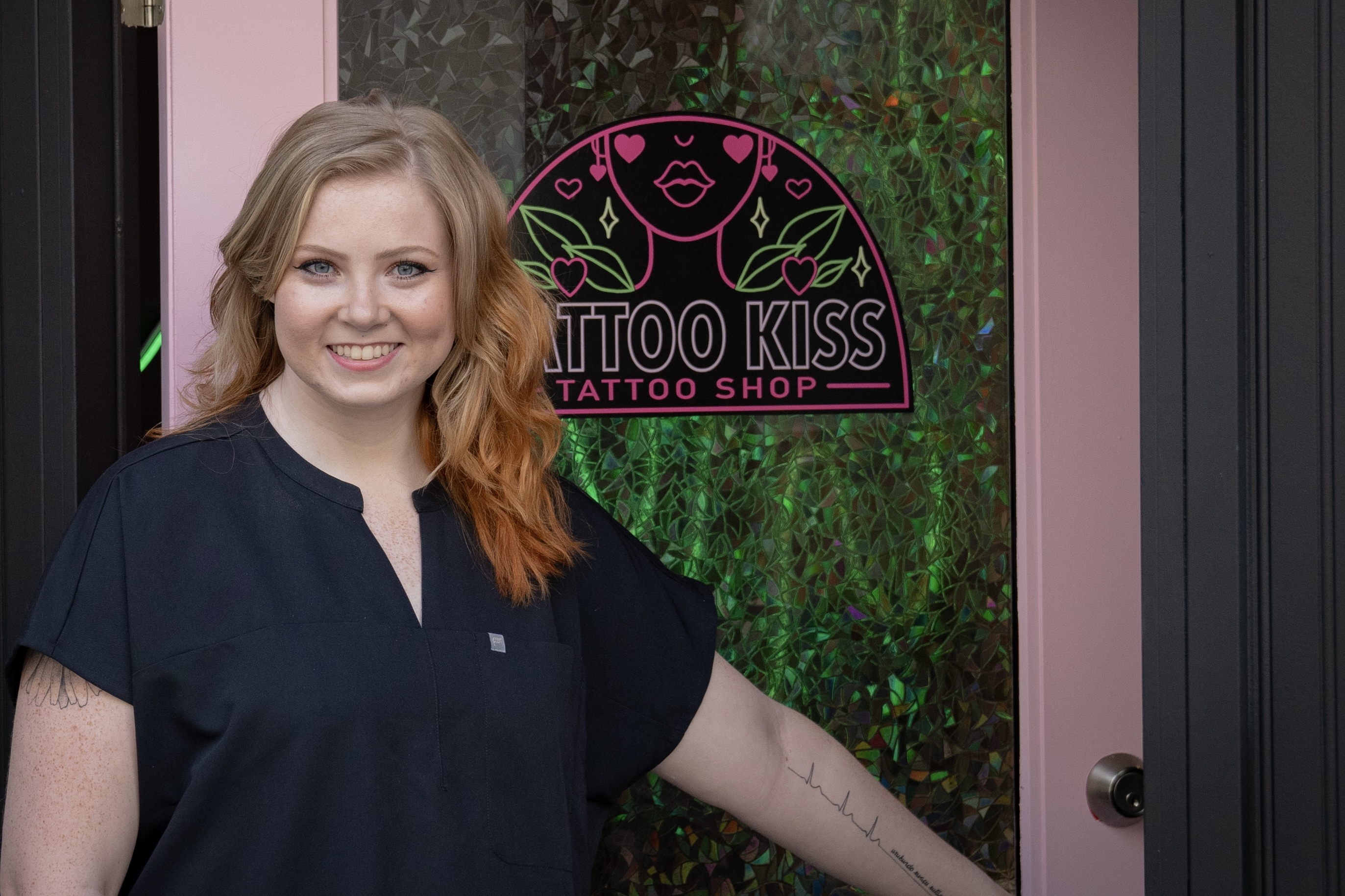 Tattoo artist welcoming clients into Tattoo Kiss studio, creating a friendly and inviting atmosphere for tattoo preparation and experiences.